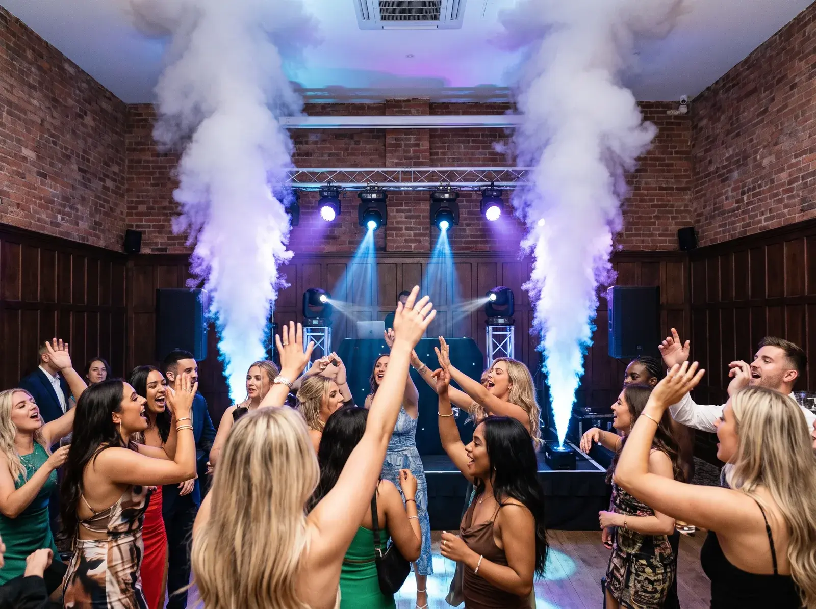 Twin vertical smoke effects over a packed dancefloor