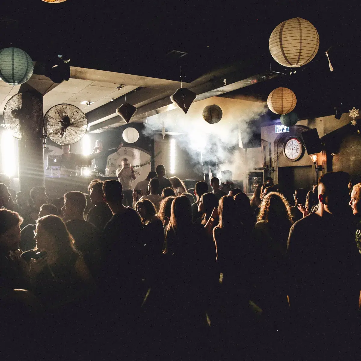 A busy venue lit with warm lantern lighting