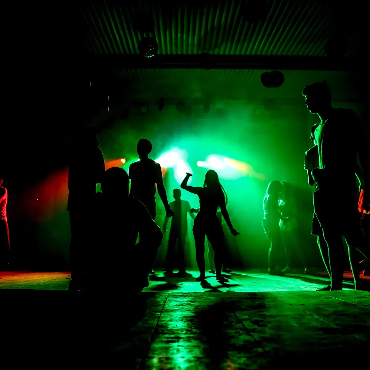 A dancefloor washed in green light
