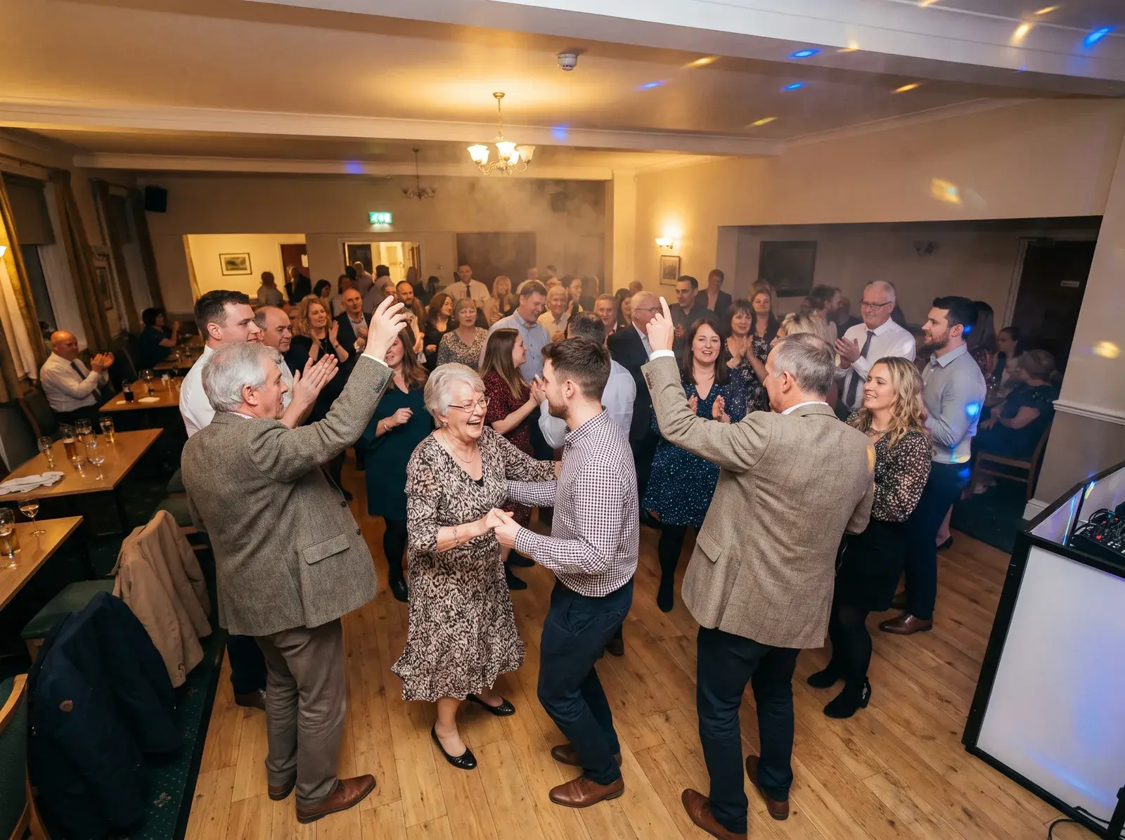 Mixed-generation family dancing together at a Feel the Presha 60th birthday party